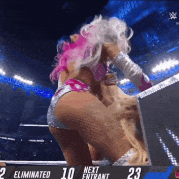 a female wrestler in a pink and silver outfit is eliminated in a wrestling match