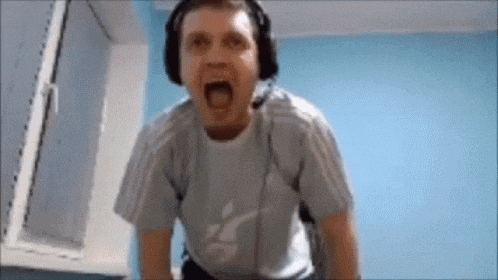 a man wearing headphones is making a funny face while standing in front of a window .