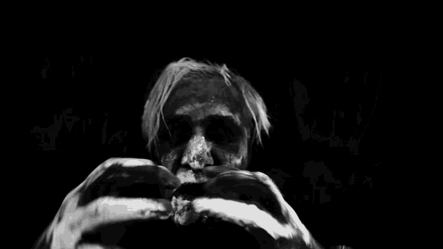 a black and white photo of a person 's face with their mouth open .