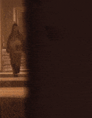 a couple of people walking down a hallway with a blue bag on the floor