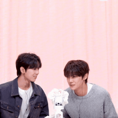two men are standing next to each other with one wearing a sweater that says ' a ' on it