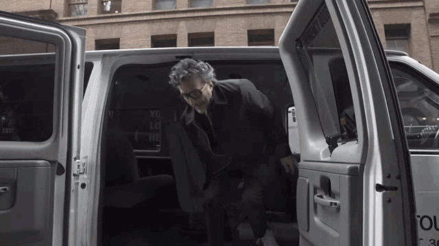 a man is getting out of a van that says emergency exit on the side