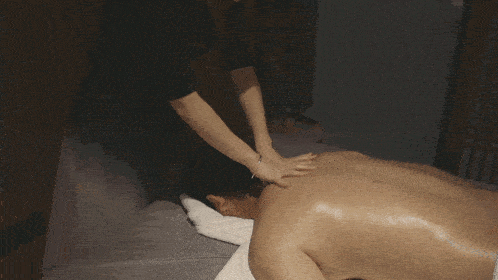 a woman is giving a man a massage on his neck