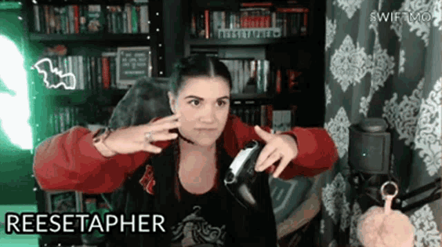 a woman wearing headphones and a red jacket with the word reesetapher on the bottom