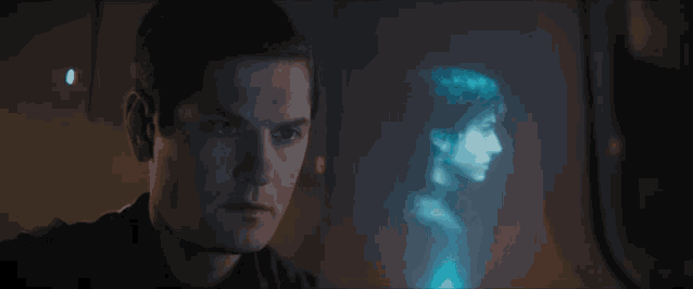 a man looks at a hologram of a woman behind him