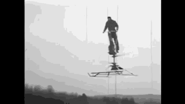 a black and white photo of a man standing on a sled