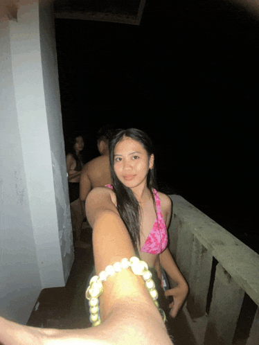 a woman in a pink bikini is taking a selfie