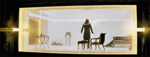 a man in a black coat stands in a room with chairs and a table