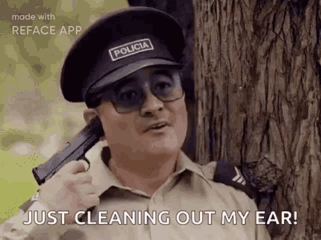 a police officer is cleaning out his ear with a gun .
