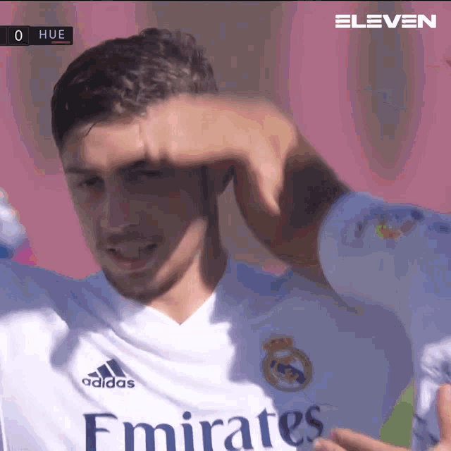 a soccer player wearing a white emirates jersey