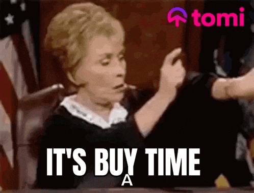 a woman is sitting in a courtroom with the words `` it 's buy time a '' written on her face .