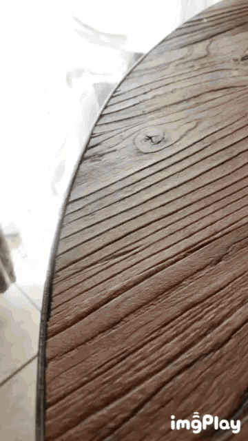 a close up of a wooden table with the words imgplay visible