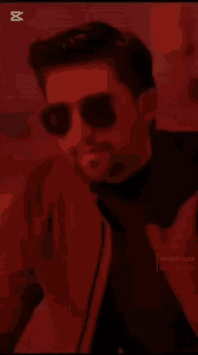 a close up of a man wearing sunglasses and a brown jacket .