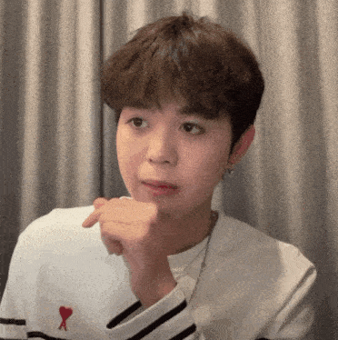 a young man wearing a white shirt with a red heart and the letter a on it