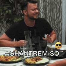 a man is sitting at a table with plates of food and the words achanrem so written on the bottom