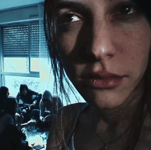 a close up of a woman 's face in front of a window