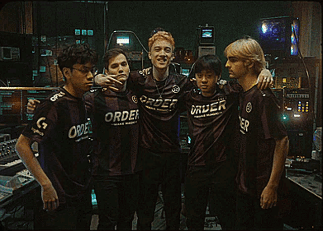 a group of young men are posing for a picture and one of them is wearing a shirt that says order