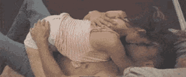 a man and a woman are laying on top of each other on a couch .