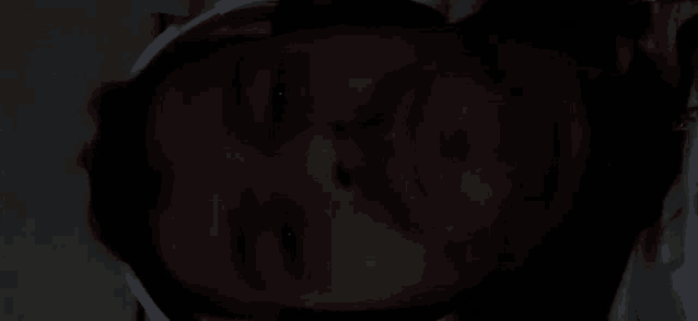 a close up of a man 's face in the dark with headphones on