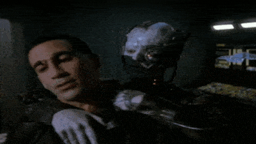 a man is being held by a robot with a glowing red eye