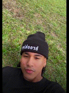 a man wearing a black beanie with the word proof written on it