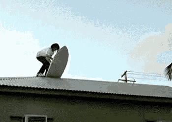 a person is riding a surfboard on top of a building .