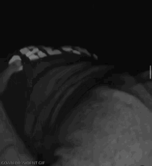 a black and white photo of a person wearing a shirt with the letter g on it