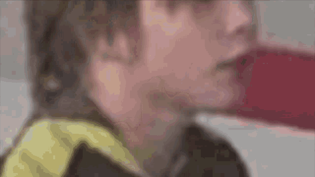 a close up of a person 's face with a yellow and black shirt on