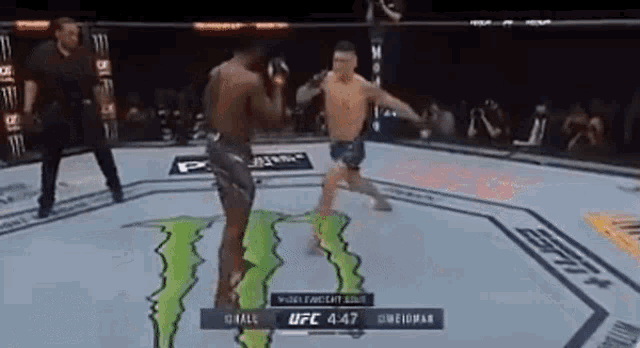 two men are fighting in a boxing ring with a monster energy drink logo on the ground