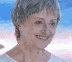 a close up of a woman 's face with a blue sky in the background