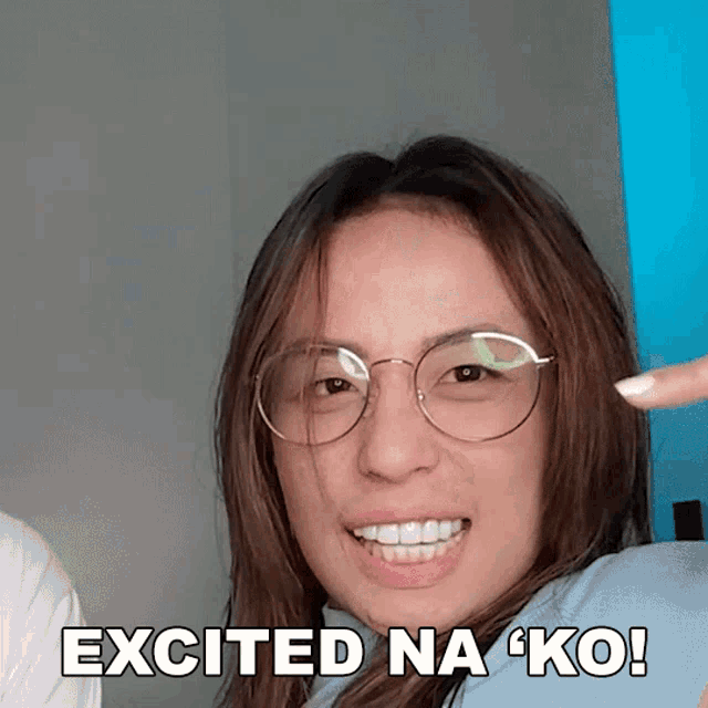 a woman wearing glasses is smiling with the words excited na ko written below her