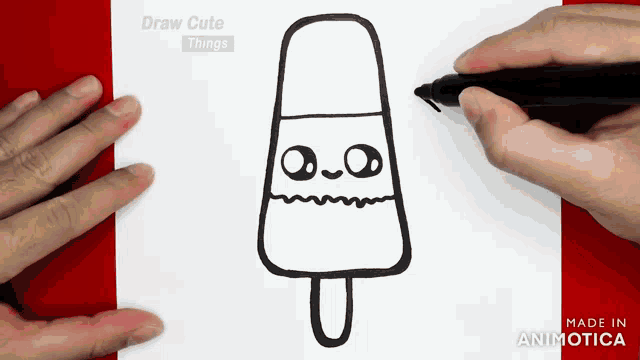 a person is drawing an ice cream on a stick with a marker