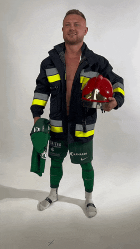 a man in a fireman costume holds a helmet