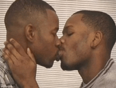 two black men are kissing each other in front of a window .