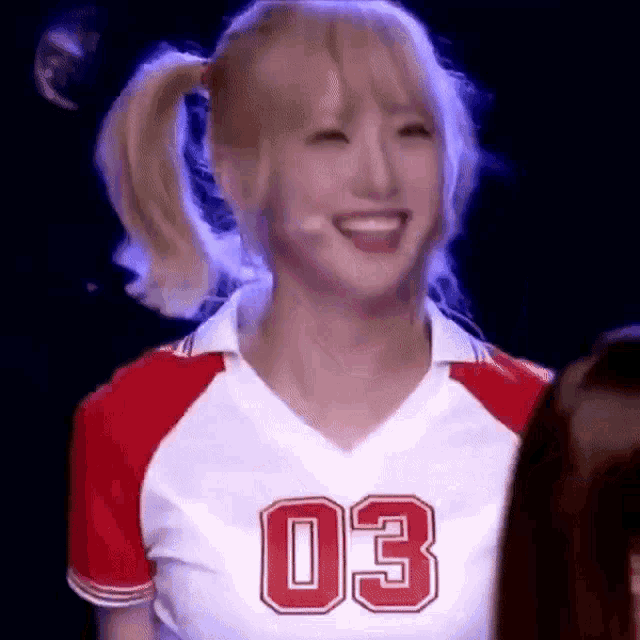 a woman wearing a red and white jersey with the number 03 on it