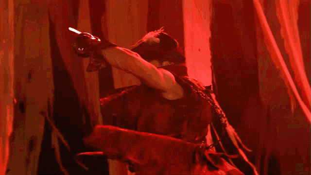 a man in a pirate outfit is holding a hook