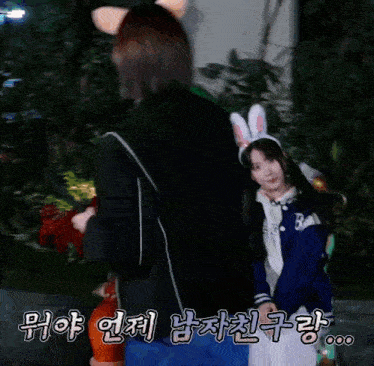 a woman in a bunny costume is standing next to another woman in a jacket