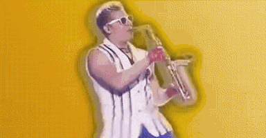 a man is playing a saxophone on a yellow background in a video .