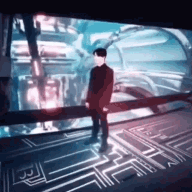 a man is standing in front of a large screen in a futuristic room .