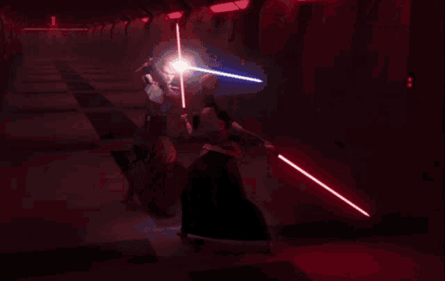 a man and woman fighting with lightsabers in a dark room
