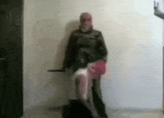 a man in a mask is standing next to a woman in a pink skirt holding a sword .