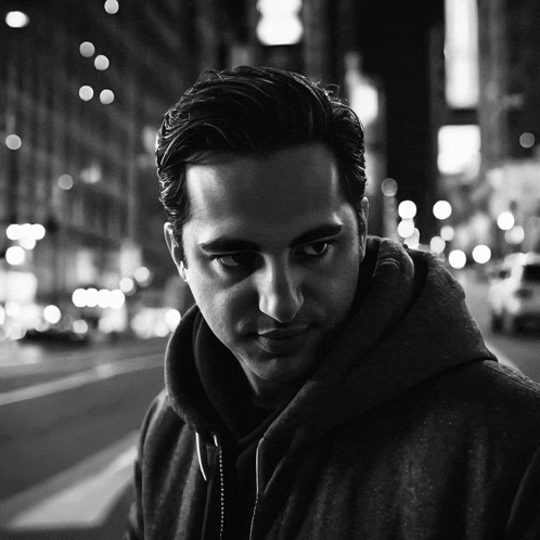 a black and white photo of a man with a hoodie on