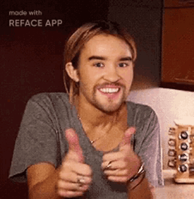 a man with a beard is smiling and giving a thumbs up
