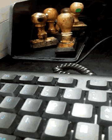 a close up of a keyboard with a few stamps behind it