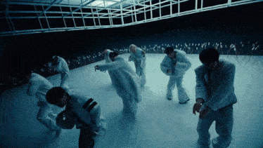 a group of people in white clothes are dancing in a room