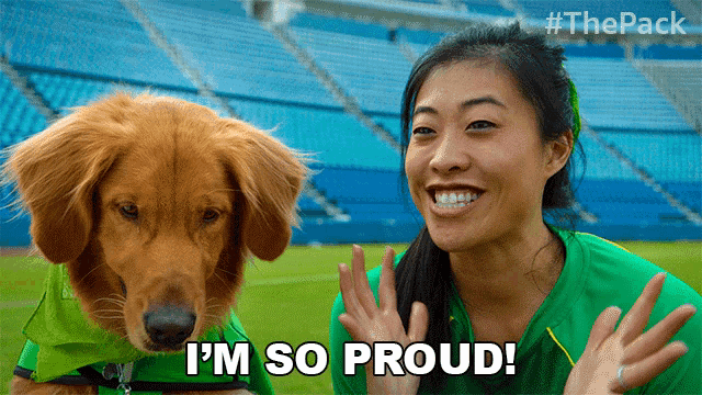a woman waving next to a dog that says " i 'm so proud " on it