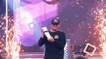 a man wearing a red bull hat holds a trophy