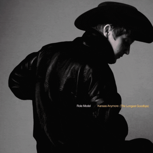 a man in a cowboy hat is holding a stuffed animal and the words role model kansas anymore on the bottom
