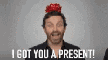 a man wearing a red bow on his head is saying i got you a present .