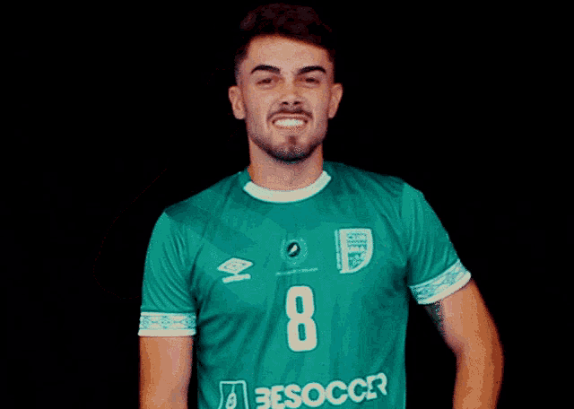 a young man wearing a green jersey with the number 8 on it